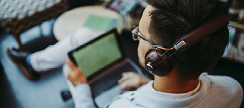 A person wearing headphones and watching on Ipad A person wearing headphones and watching on Ipad