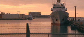 Marine cargo ship loaded with vessels on the dockyards