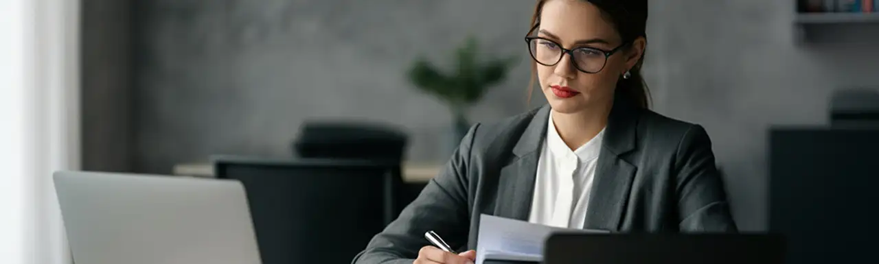 A person working on the desk with laptop and documents